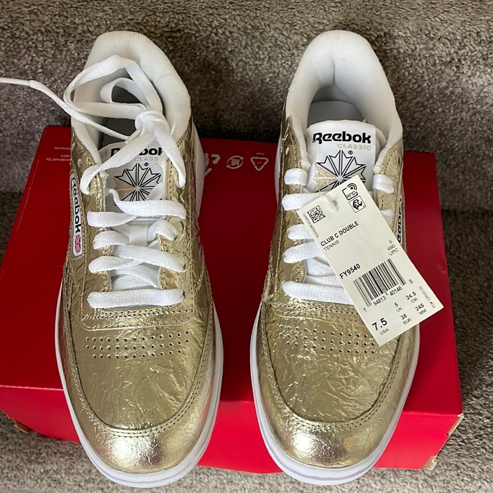 Brand new. Never worn. Gold Reebok . Women’s 7.5